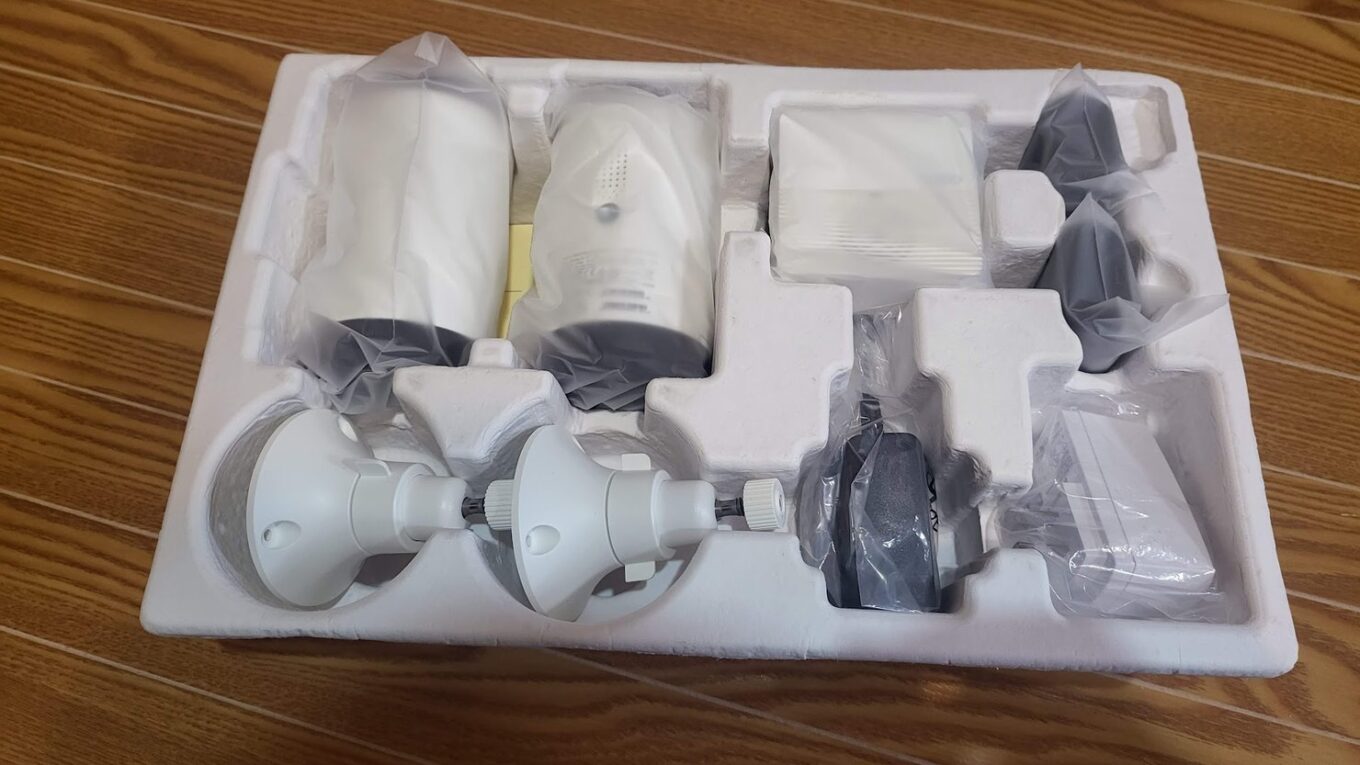 Tapo C420S2 の内容物。発泡スチロールにカメラ2台・親機・台座・充電ケーブルが収まっている